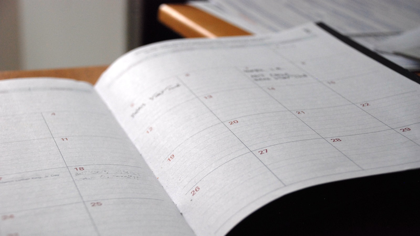 Openliggende agenda met een maandkalender op een bureau